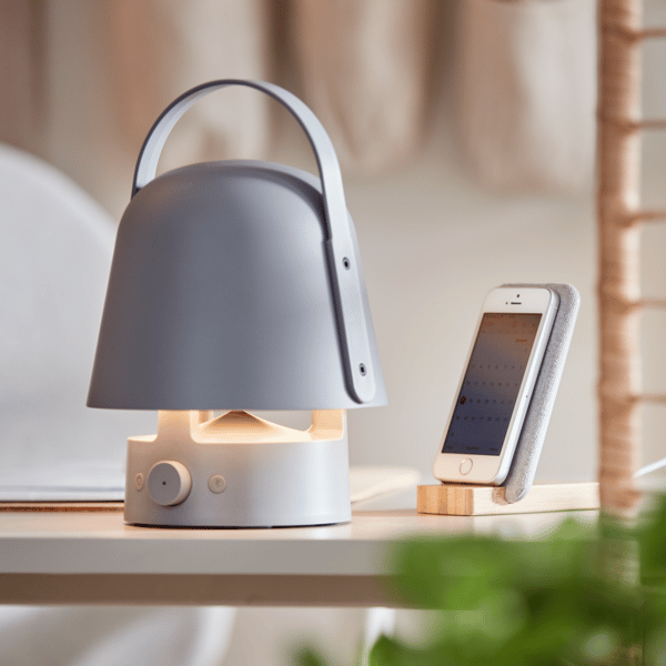 Un altavoz portatil de la serie VAPPEBY sobre una mesa y un movil al lado