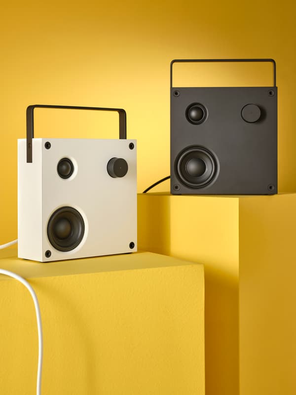 Un altoparlante bluetooth VAPPEBY bianco e uno nero su due cubi gialli davanti a uno sfondo giallo messo sotto i riflettori