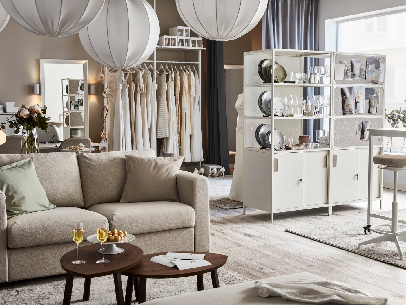 Un ambiente ampio e luminoso con un divano VIMLE, due mobili TROTTEN, un grappolo di lampade a sospensione REGNSKUR e decorazioni varie.