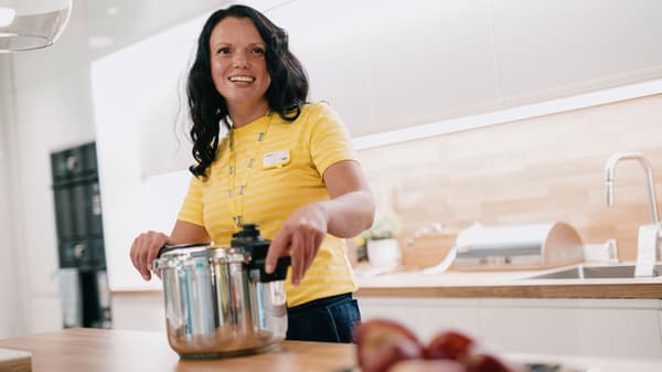 Un angajat IKEA care ajută un client să-și proiecteze bucătăria folosind instrumentul de planificare a bucătăriilor.