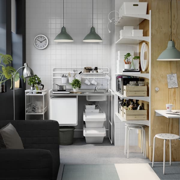 Un apartamento pequeño con una mini cocina modular SUNNERSTA al fondo.