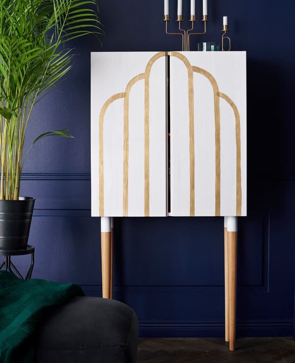 Un armari IKEA IVAR de fusta massissa on s'ha pintat un motiu i que s'ha col·locat davant una paret blava.