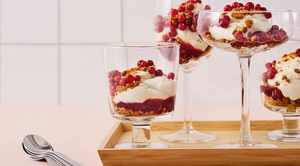 Un assortiment de coupes élégantes remplies de gâteau au fromage avec des miettes de pain d’épice et de la confiture d’airelles