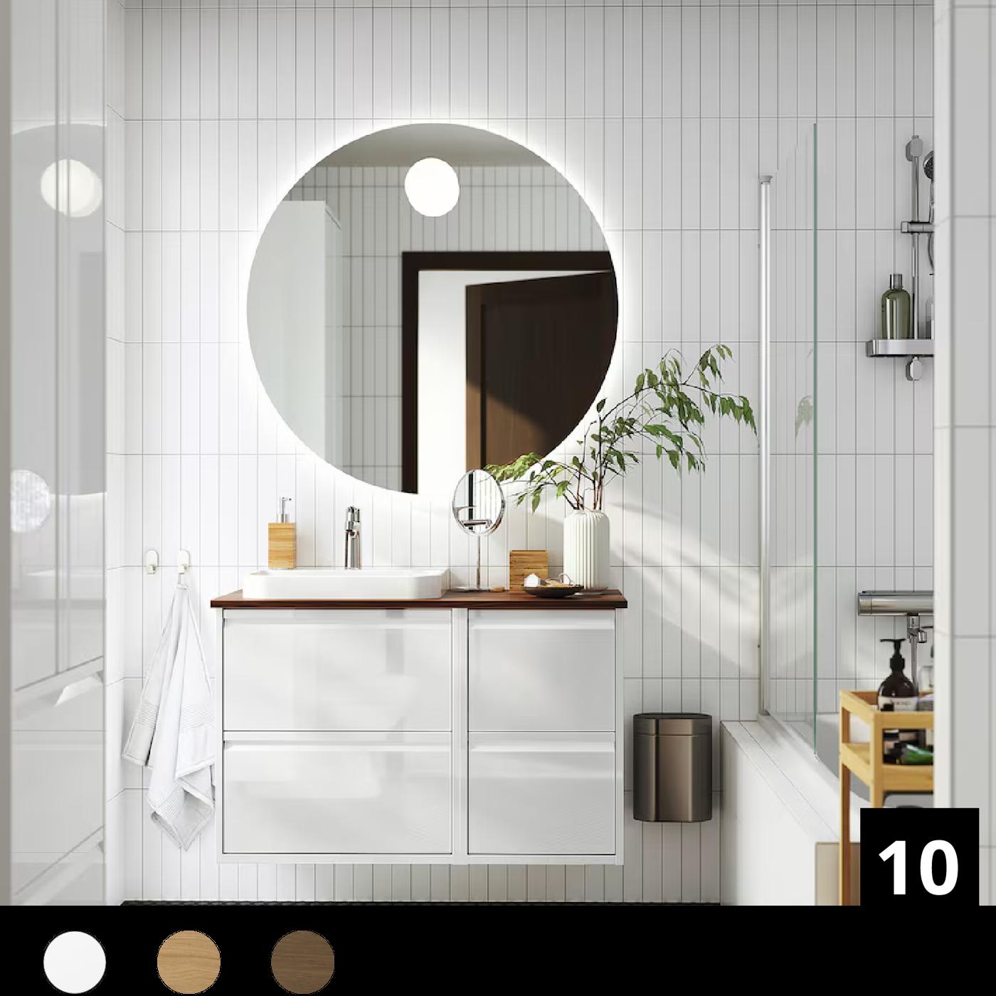 Un bagno ÄNGSJÖN bianco con mobile lavabo con due cassetti, specchio quadrato e alcuni accessori per la toilette.
