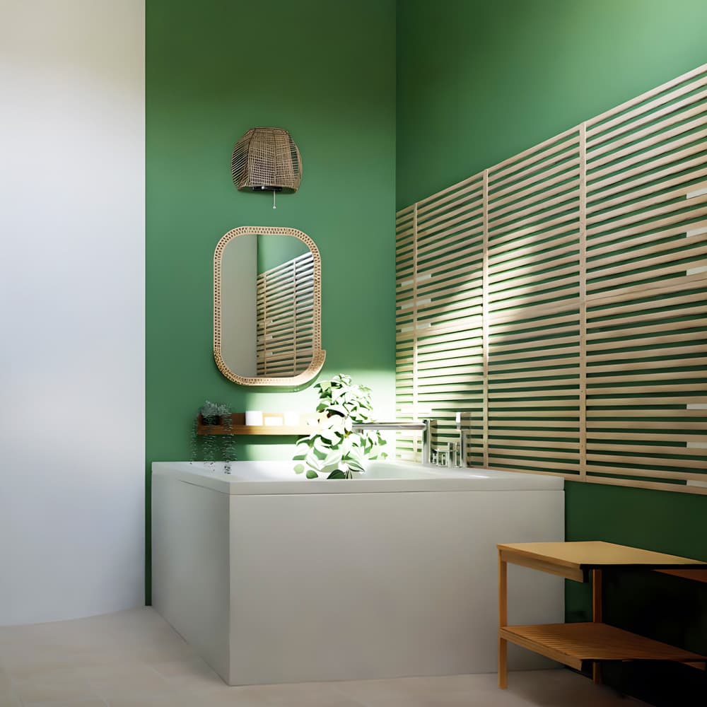 Un bagno con una vasca e pareti verdi. Sopra la vasca, c'è uno specchio SOMMARBO con una lampada da parete MÅNALG e accanto un tavolino.