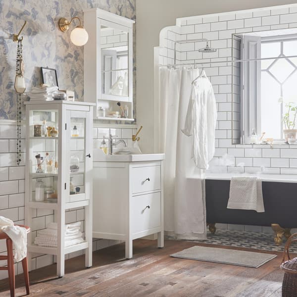 Un bagno in stile tradizionale con mobili di colore bianco HEMNES e una vasca grigia free standing. A lato, una fienstra aperta da cui entra luce.