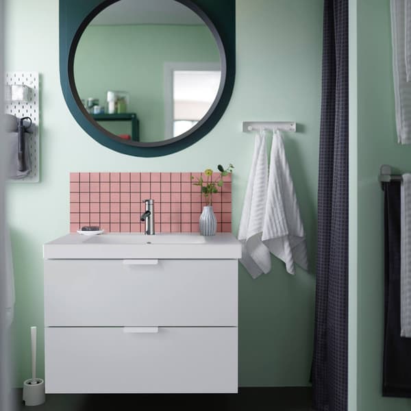 Un bagno moderno con mobile e lavabo integrato. Alla parete, ci sono uno specchio todno e dei ganci con appesi degli asciugamani.