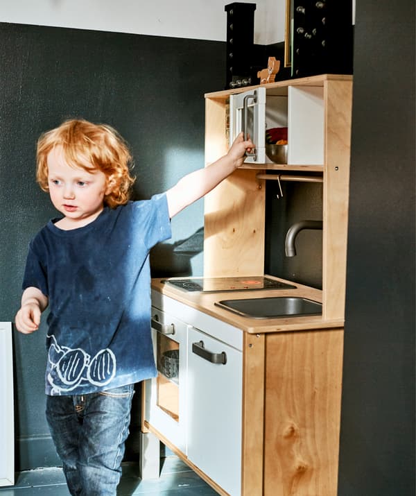 Un bambino che gioca con una cucina gioco.
