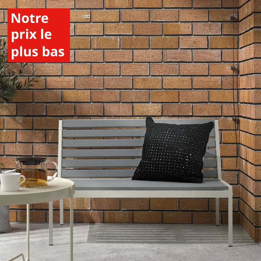 Un banc d'extérieur gris et blanc avec un coussin noir, une table basse et une théière