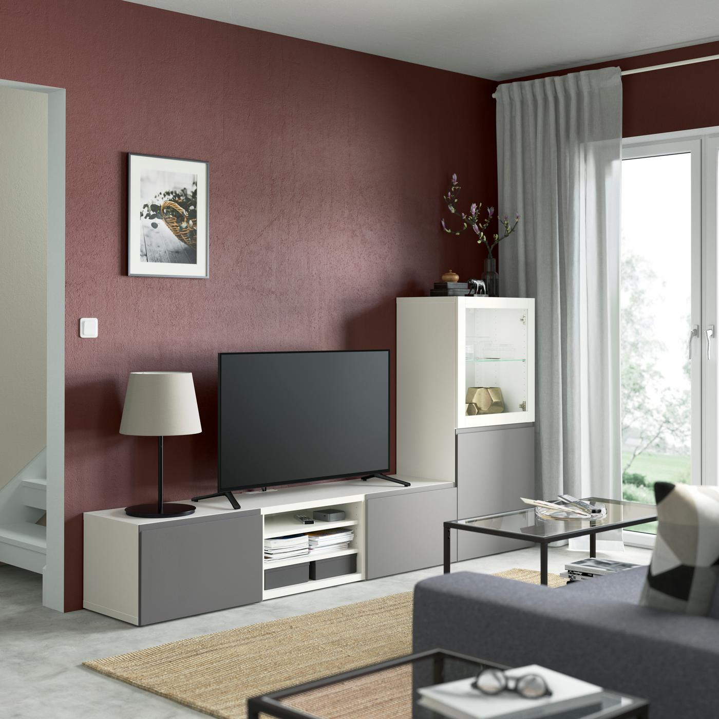 Un banc TV BESTA devant une table basse en verre.