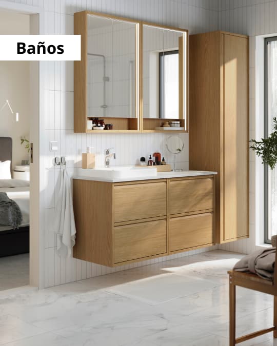 Un baño con mueble flotantes efecto madera y un botiquín de dos puertas.