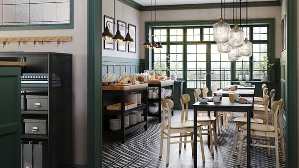Un bar con pannelli verdi alle pareti e tavoli TOMMARYD in betulla, sedie RÖNNINGE in betulla e due isole per cucina VADHOLMA - IKEA.