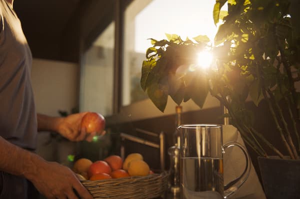 Un bărbat aducând fructe pe balcon la apus.