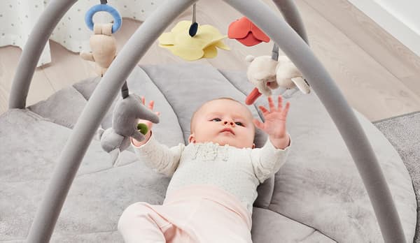 Un bebé juega con un gimnasio infantil GULLIGAST.
