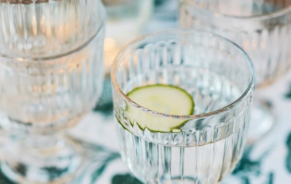 Un bicchiere d’acqua con una fetta di cetriolo.