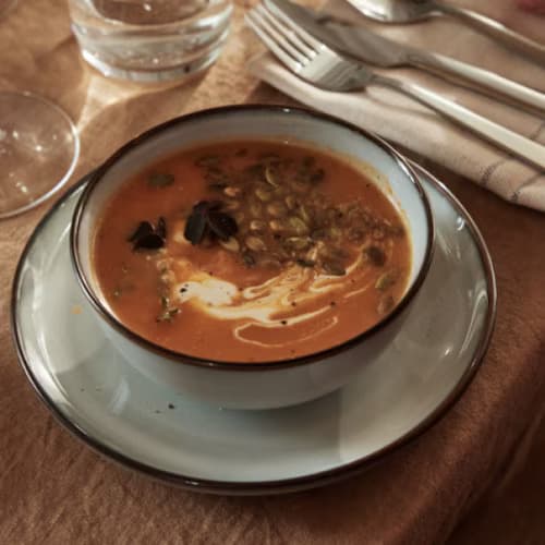 Un bol de soupe sur une assiette blanche