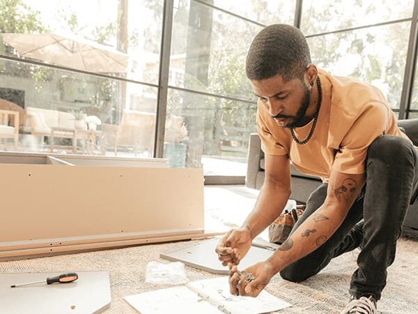 Un bricoleur assemble des meubles IKEA chez un client.