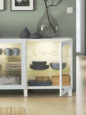 Un buffet avec des portes vitrées GLASSVIK ouvertes.