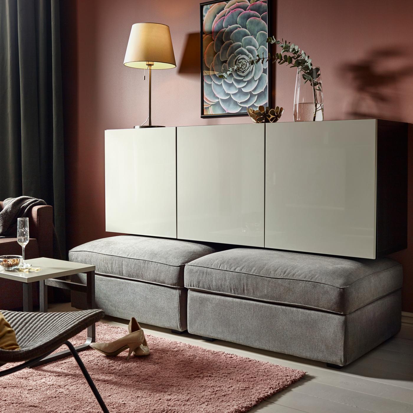 Un buffet positionné juste au-dessus de deux chauffeuses grises.