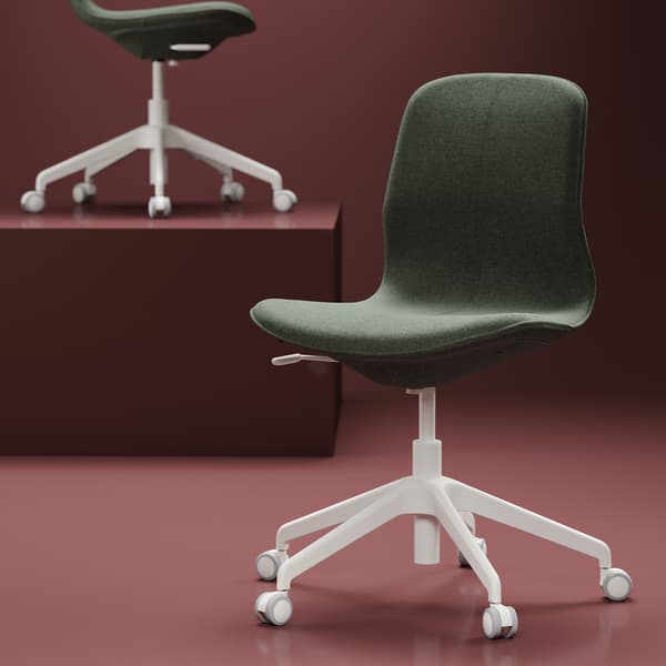 Un bureau à domicile de style traditionnel avec un fauteuil en cuir à roulettes. 