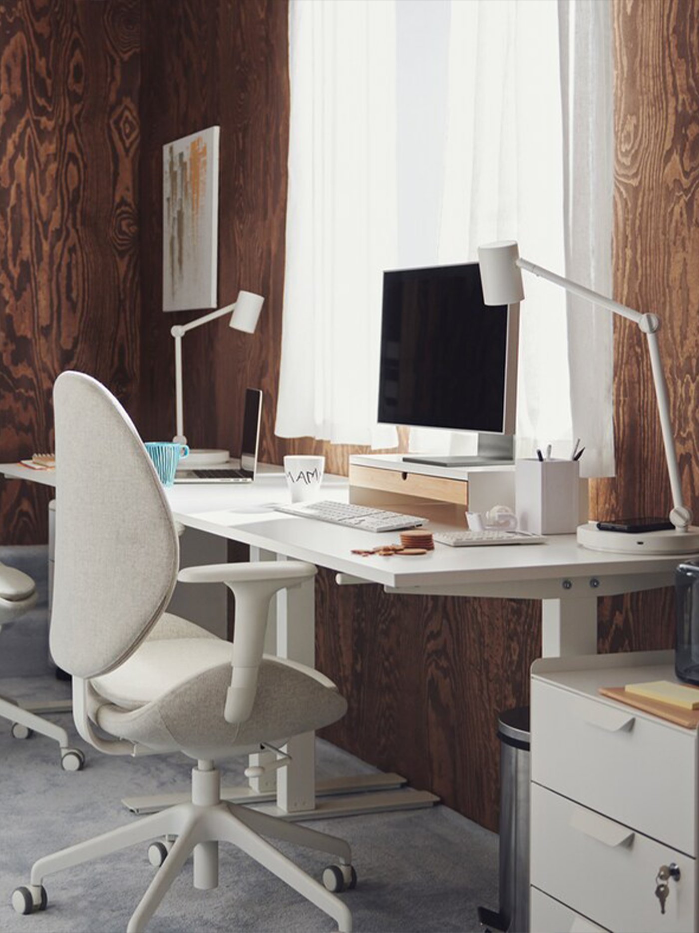 Un bureau à domicile moderne et minimaliste avec un bureau blanc, une chaise ergonomique et une lumière naturelle douce