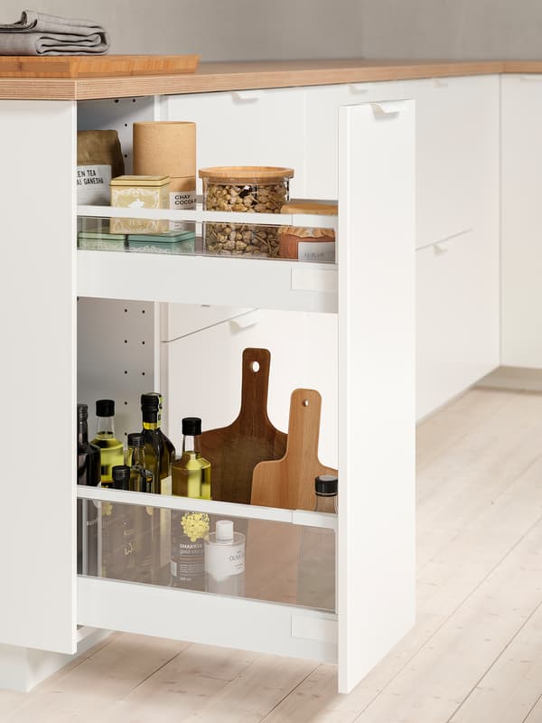 Un calaix blanc completament obert on es poden veure els productes emmagatzemats, com olis i condiments.