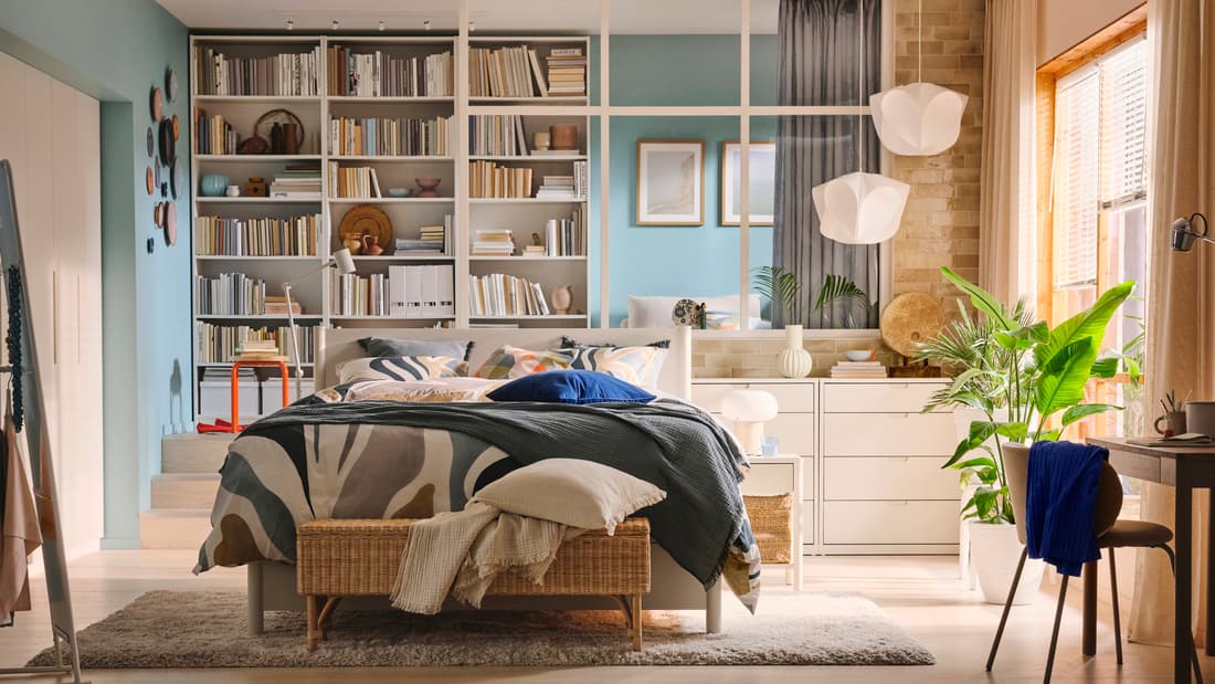 Un camera divisa in due con un letto TONSTAD e con una libreria in fondo alla stanza. 