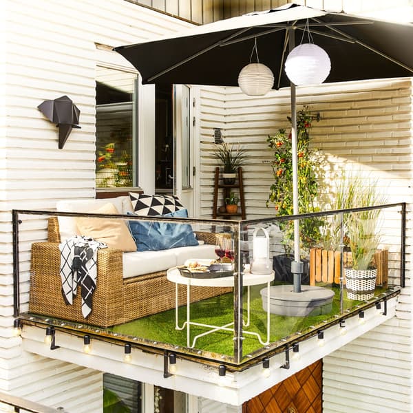 Un canapé d’extérieur 2 places moderne brun/beige SOLLERÖN posé sur un petit balcon avec une table basse et un parasol