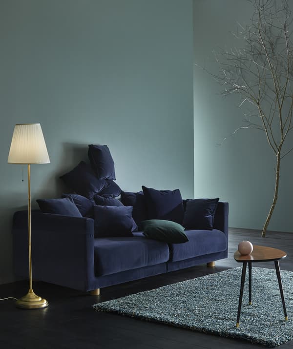 Un canapé en velours bleu dans un séjour.