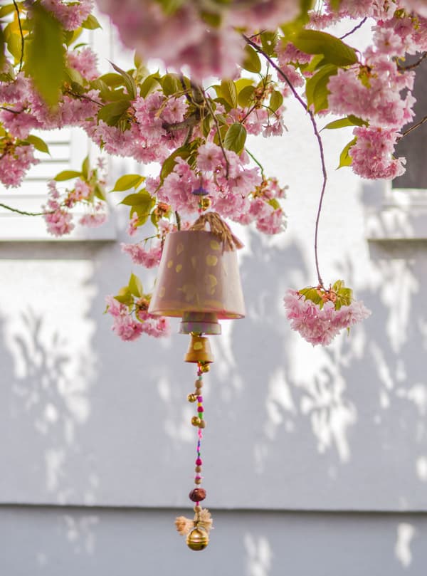Un carillon éolien en forme de pot de fleurs suspendu à un arbre