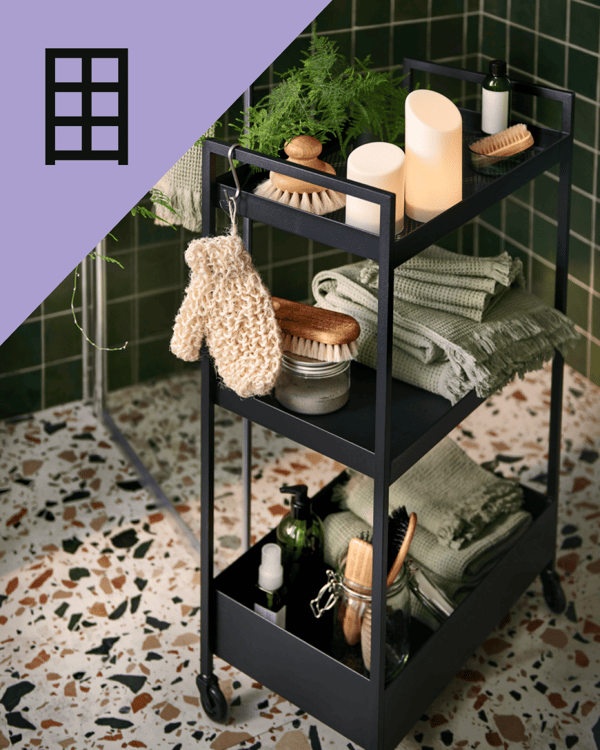 Un carrito organizador de IKEA con artículos de bañño como toallas, cepillos.