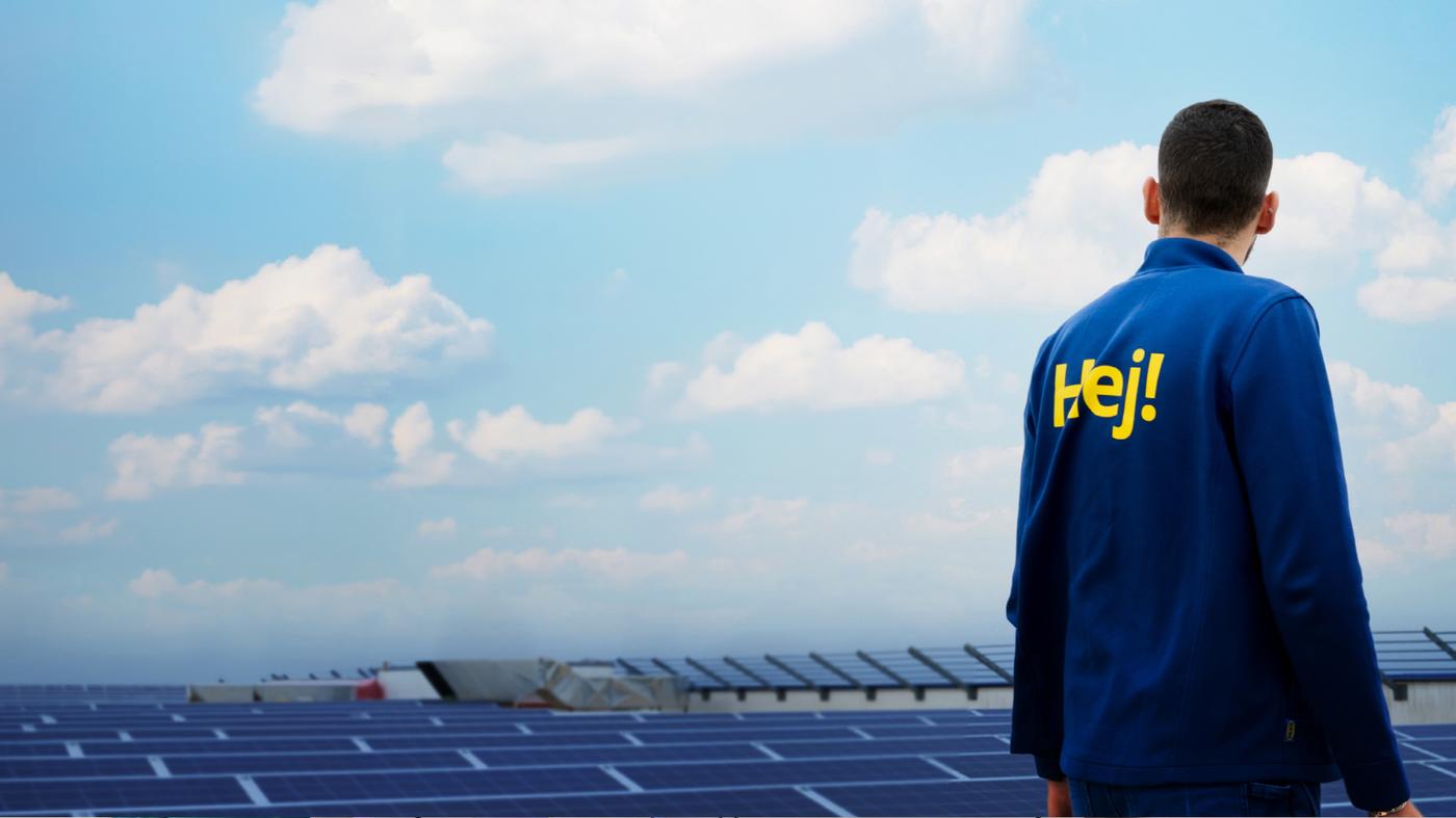 Un co-worker IKEA davanti a una distesa di pannelli solari. 