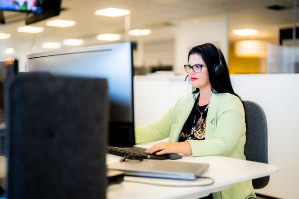 Un co-worker IKEA impegnato a rispondere a una richiesta di informazioni da parte di un cliente presso un Service Desk IKEA.