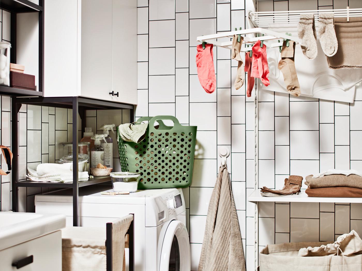 Un coin buanderie avec un lave-linge, une combinaison de rangement et un séchoir SLIBB où des chaussettes sont suspendues.