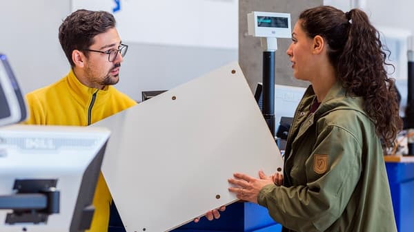 Un collaborateur et une cliente échangent la planche d'un meuble