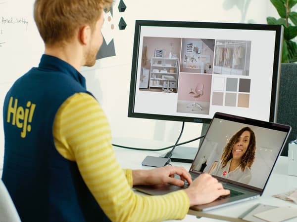 un  collaborateur IKEA parle en visio avec un cliente et regarde un nuancier sur un autre écran