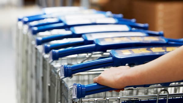 Un collaborateur IKEA poussant un convoi de caddies dans un magasin IKEA.