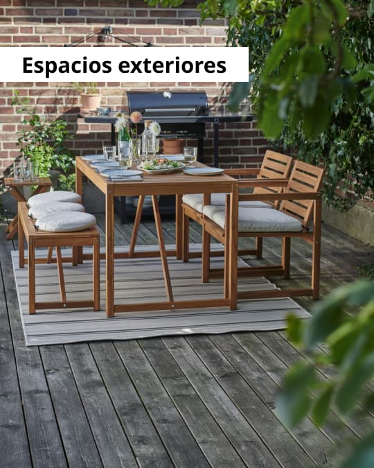 Un comedor de terraza con muebles de madera sobre una alfombra de exterior.
