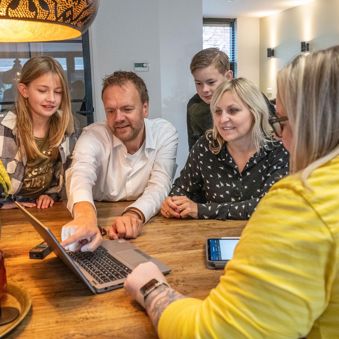Un compañero/a de IKEA planificando una cocina con una familia en su casa.