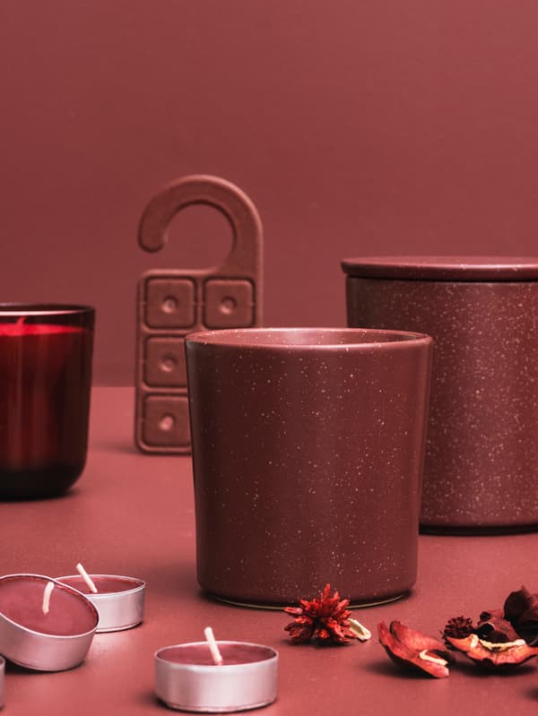 Un conjunt d'espelmes STÖRTSKÖN amb aroma de fruites del bosc, popurri i un ambientador per a l'armari davant d'un fons de color rosa clar.