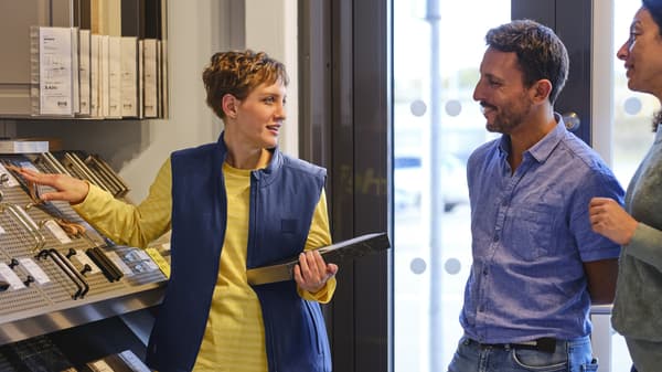 Un conseiller IKEA qui aide des clients sur la conception.