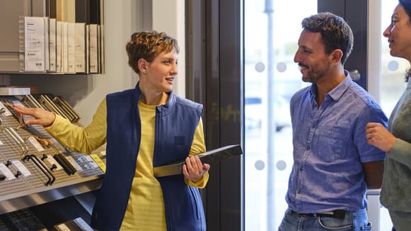 Un conseiller IKEA qui aide des clients sur la conception.