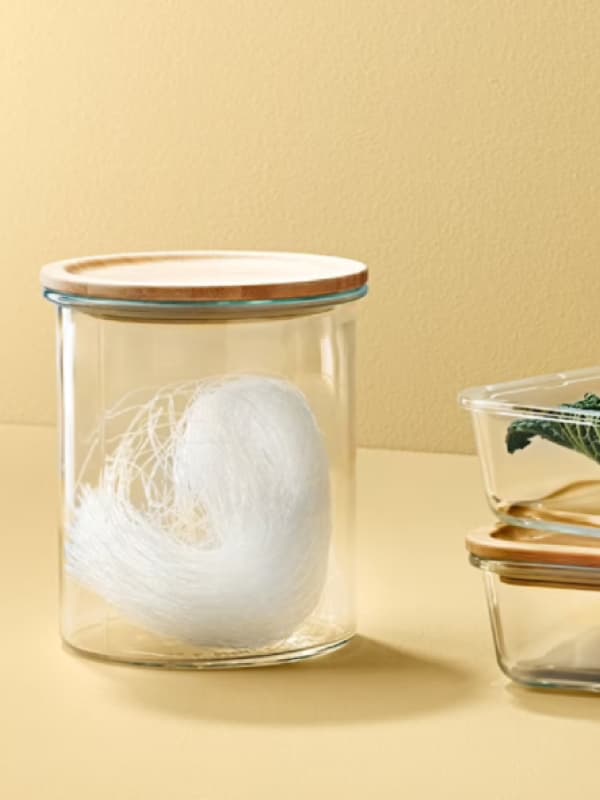 Un contenitore in plastica con coperchio in legno e accanto due contenitori rettangolari.