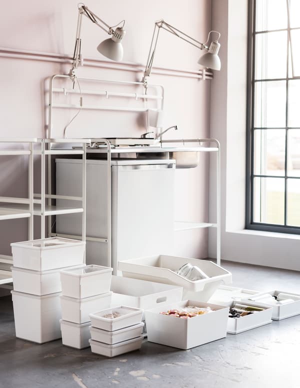 Un conxunto de caixas de almacenaxe brancas, entre elas, caixas de plástico branco IKEA KUGGIS con tapa para gardar alimentos e utensilios.