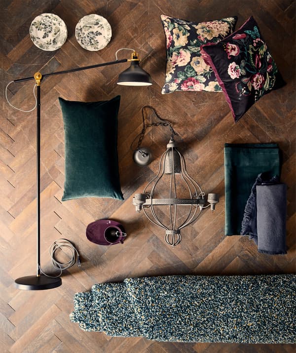 Un coussin IKEA SARALENA et une collection d’autres articles d’ameublement posés sur un plancher en bois.