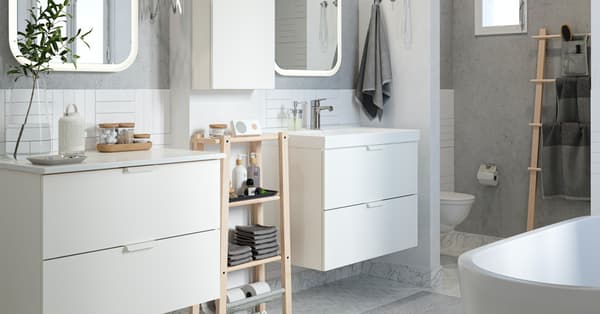 Un cuarto de baño con lavabo para él y para ella, armarios y una bañera.