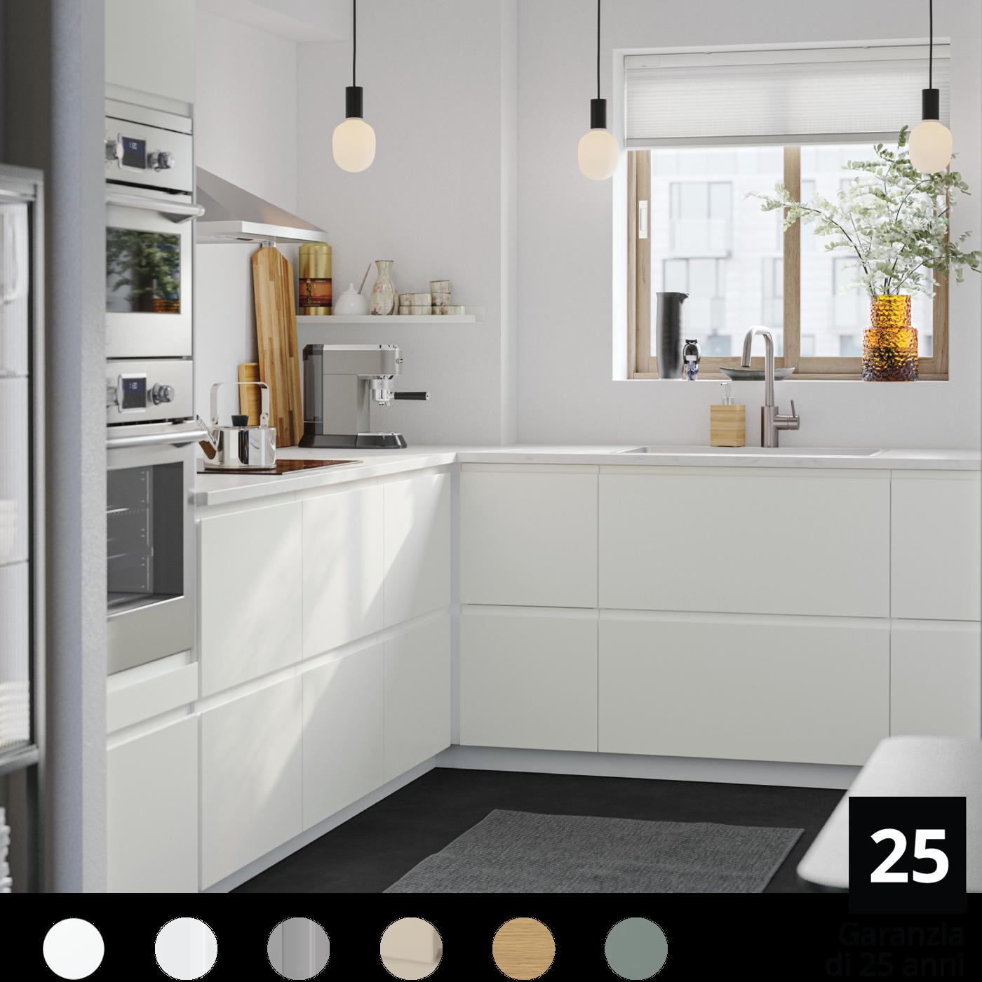 Un cucina METOD con cassetti, lampade a sospensione, forno, cappa da parete e piano di lavoto con utensili e una mensola bianca.