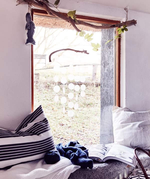 Un davanzale con plaid e cuscini a righe.