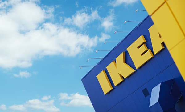 Un día despejado y soleado donde se aprecia una esquina de la icónica tienda de IKEA, con sus colores azules y amarillo. Se aprecia el logo grande.