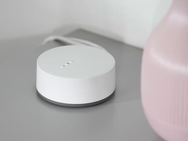 Un dispositiu de connexió TRÅDFRI sobre una taula auxiliar d'IKEA.